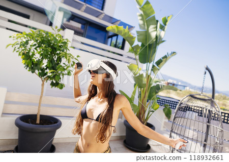 Experience captivating virtual reality in a sunny outdoor setting with palm trees and greenery 118932661