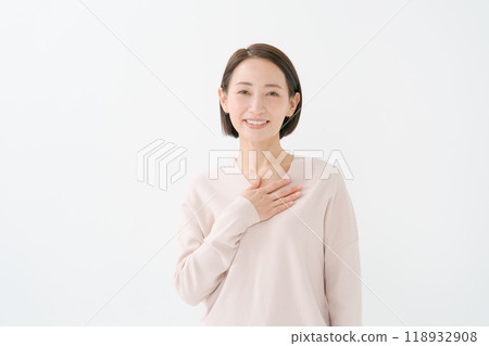 A woman holding her hand on her chest 118932908