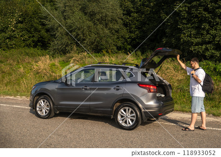 Man with Backpack at Open Car Trunk Man with Backpack at Open Car Trunk 118933052