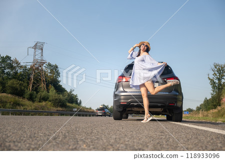 Cheerful Woman Posing by SUV on Sunny Day Cheerful Woman Posing by SUV on Sunny Day 118933096