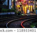 Railroad tracks at night with city lights reflecting 118933401