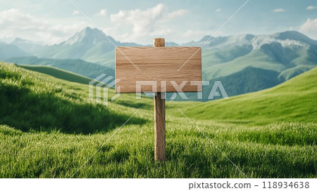 A rustic wooden sign stands in a vibrant green meadow, surrounded by majestic mountains under a clear blue sky. 118934638
