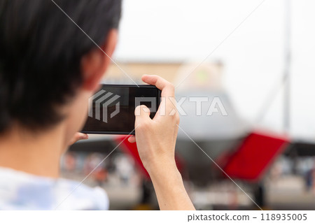 A person taking a photo using a smartphone A person taking a photo using a smartphone 118935005