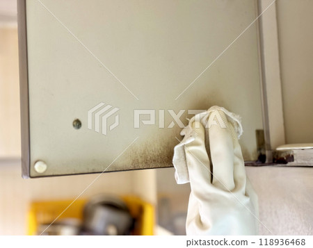 Hands in vinyl gloves cleaning the inside of an old kitchen cabinet Hands in vinyl gloves cleaning the inside of an old kitchen cabinet 118936468