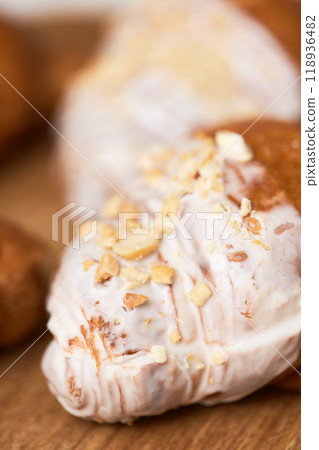 Delicious fresh croissants in glaze on wooden tray, closeup 118936482