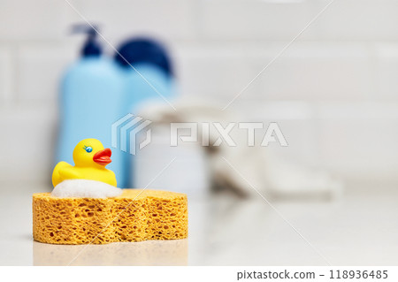 Yellow rubber duck, soap, bath foam on bath background, baby bath accessories Yellow rubber duck, soap, bath foam on bath background, baby bath accessories 118936485