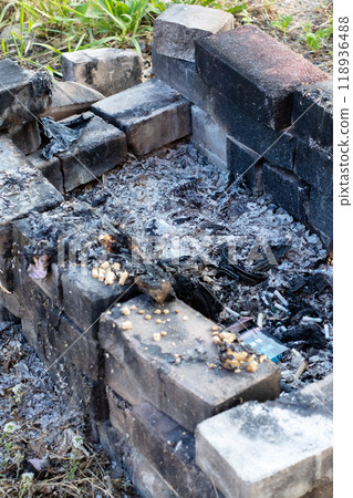 A fire pit that has been constructed using bricks set in the dirt 118936488