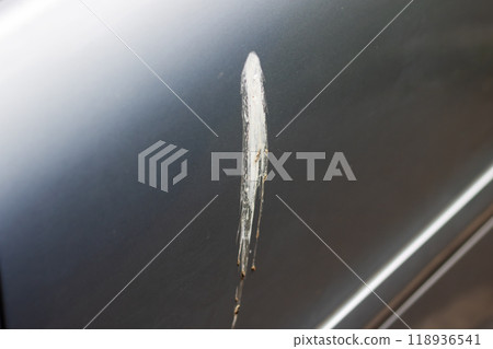 A silver car that has a noticeable scratch on its door area A silver car that has a noticeable scratch on its door area 118936541