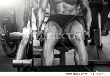 Strong muscular bodybuilder doing legs with machine Strong muscular bodybuilder doing legs with machine 118937480