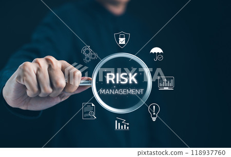 Professional Exploring Risk Management Concepts. Businessman focuses on a magnifying glass highlighting risk management icons, emphasizing strategies for minimizing business risks. Risk assessment, 118937760