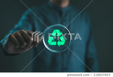 Sustainable development planning. Businessman holding magnifying glass with glowing green recycling icon, representing the concept of sustainability, environmental conservation, eco-friendly practices 118937853
