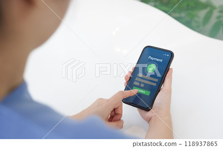 Secure Online Payment Transaction Process concept. Person confirming a secure online payment using a credit card through a digital interface with verification tick symbol. Internet banking, fintech, Secure Online Payment Transaction Process concept. Person confirming a secure online payment using a credit card through a digital interface with verification tick symbol. Internet banking, fintech, 118937865