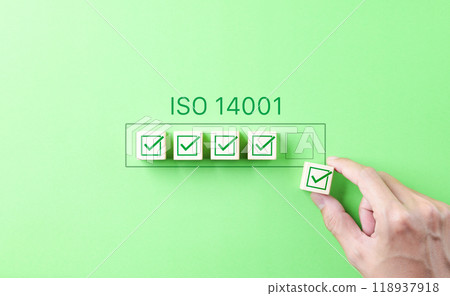 ISO 14001 Environmental Management Certification Concept. Hand places a checkmark block under the ISO 14001 label, symbolizing quality control, certification for environmental management systems (EMS) ISO 14001 Environmental Management Certification Concept. Hand places a checkmark block under the ISO 14001 label, symbolizing quality control, certification for environmental management systems (EMS) 118937918