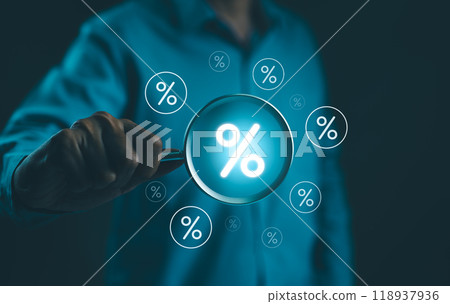 Interest Rate and Dividend Concept. Businessman holds a magnifying glass with virtual percentage symbols surrounding it, representing interest rate and dividend concepts in financial analysis. Interest Rate and Dividend Concept. Businessman holds a magnifying glass with virtual percentage symbols surrounding it, representing interest rate and dividend concepts in financial analysis. 118937936