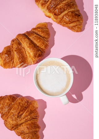 Flat lay of coffee cup and fresh croissants on pink background with shadow. Flat lay of coffee cup and fresh croissants on pink background with shadow. 118938048