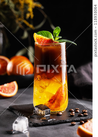 Coffee with orange juice (bumble) in a tall glass with ice and mint on a dark background Coffee with orange juice (bumble) in a tall glass with ice and mint on a dark background 118938064