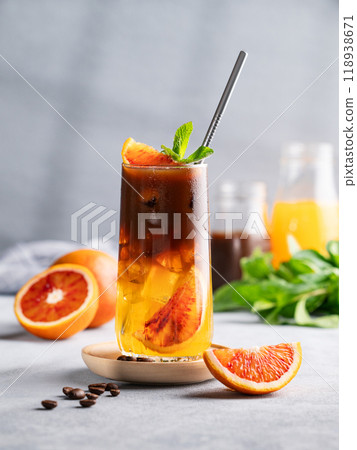Espresso coffee with orange juice (bumble) in a tall glass with ice and mint on a blue background 118938671