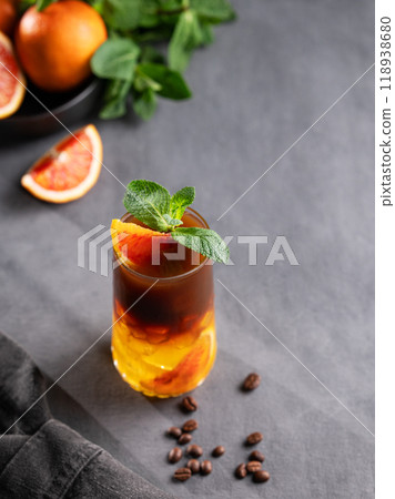 Coffee with orange juice (bumble) in a tall glass with ice and mint on a dark background 118938680