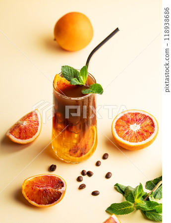 Espresso coffee with orange juice (bumble) in a tall glass with ice and mint on a yellow background Espresso coffee with orange juice (bumble) in a tall glass with ice and mint on a yellow background 118938686