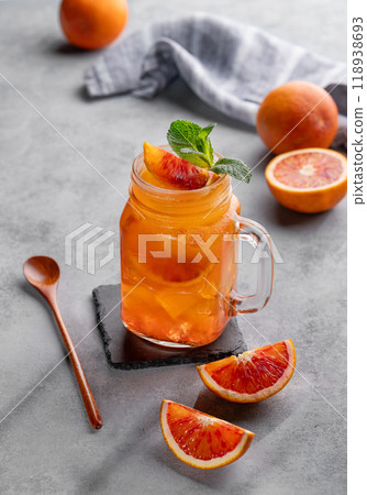 Freshly squeezed blood orange juice with ice, mint and a slice of fruit in a jar on blue background Freshly squeezed blood orange juice with ice, mint and a slice of fruit in a jar on blue background 118938693