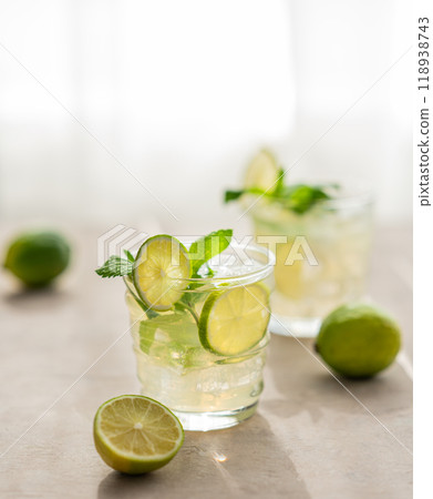 Two glasses citrus lemonade with mint and ice. Refreshing mojito cocktail with lime Two glasses citrus lemonade with mint and ice. Refreshing mojito cocktail with lime 118938743