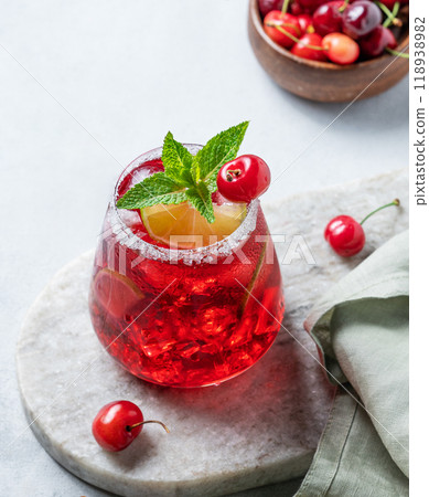 Cherry-lime mojito cocktail with mint, lime and ice on a marble board on a light background Cherry-lime mojito cocktail with mint, lime and ice on a marble board on a light background 118938982