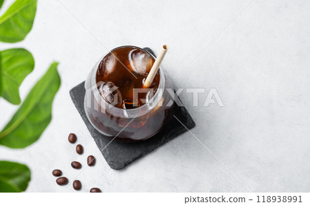 Coffee espresso in a glass with ice on a black board on a light background with coffee beans 118938991
