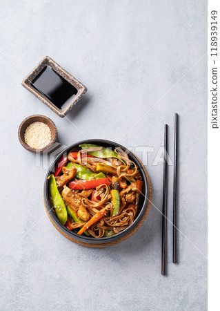 Stir-fry with soba noodles, meat and vegetables on a light background. 118939149