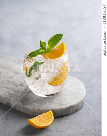 Lemonade tonic drink with fresh lemon, mint and ice on a marble board on a light background. Lemonade tonic drink with fresh lemon, mint and ice on a marble board on a light background. 118939157