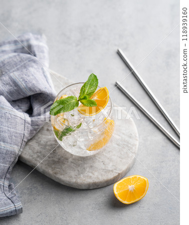 Lemonade tonic drink with fresh lemon, mint and ice on a marble board on a light background. 118939160