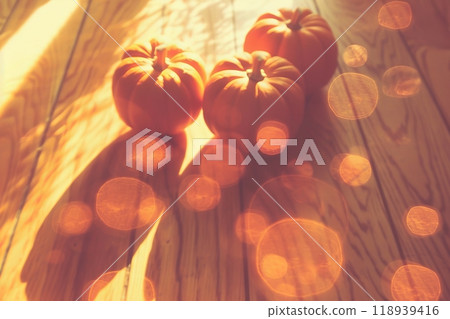 Halloween scene bright orange pumpkins on wooden table with glowing bokeh background 118939416