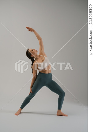 Young woman practicing yoga in a studio during a calm evening 118939599