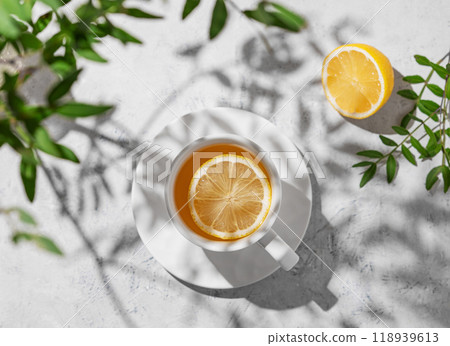 A cup of tea with lemon and green branch on a white table.  Breakfast detox and healthy concept. 118939613