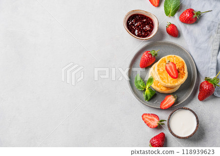 Cottage cheese, cheesecakes or syrniki with sour cream, jam, strawberries and mint leaves Cottage cheese, cheesecakes or syrniki with sour cream, jam, strawberries and mint leaves 118939623