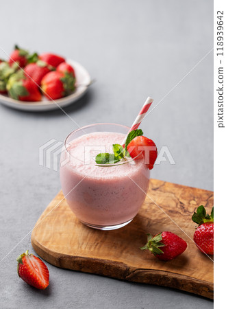 A glass of fresh strawberry smoothie with mint on a wooden board on a light background A glass of fresh strawberry smoothie with mint on a wooden board on a light background 118939642