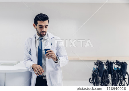 doctor in white coat Standing using cellphone applications in clinic office. Man with healthcare, medical and wellness app on mobile technology or search internet doctor in white coat Standing using cellphone applications in clinic office. Man with healthcare, medical and wellness app on mobile technology or search internet 118940028