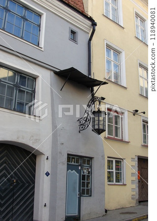 Facade of a historic building with a lantern. Old European-style building with a door and windows. Exterior of a building street with a decorative lantern Facade of a historic building with a lantern. Old European-style building with a door and windows. Exterior of a building street with a decorative lantern 118940081