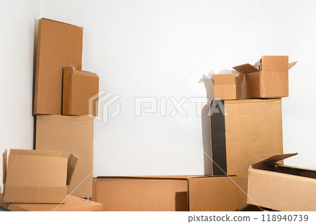Creative minimalist image of stacked cardboard boxes on a plain background, representing concepts of moving, storage, shipping, and organization. Ideal for themes of simplicity and efficiency. 118940739