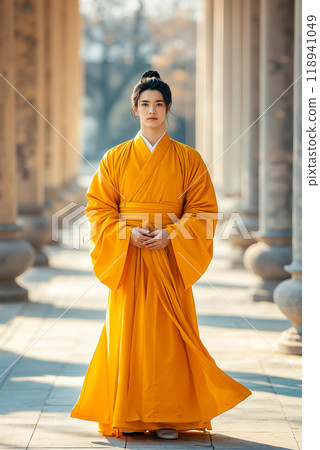 A woman in a yellow kimono standing in front of a row of pillars 118941049