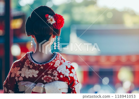 A woman in a red kimono with a flower in her hair 118941053