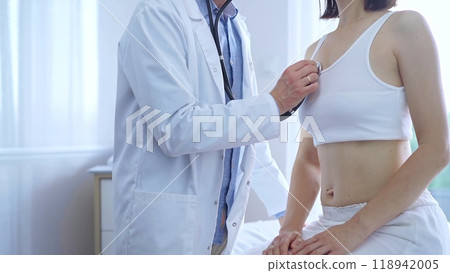 Doctor and patient. Physician is using stethoscope examining woman lungs in clinic cabinet. Medicine and health care 118942005