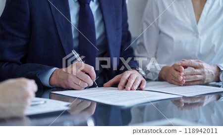 Business people wearing suits signing important documents during a corporate meeting. Win-win concept Business people wearing suits signing important documents during a corporate meeting. Win-win concept 118942011