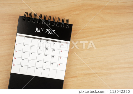 July desk calendar for 2025 year on wooden floor. 118942230