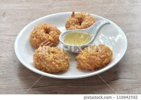 crispy fried mashed shrimp cake coating flake bread and flour on plate dipping with sweet plum sauce 118942592