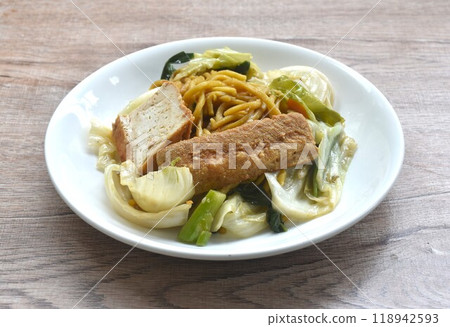 fried yakisoba noodles and cabbage with carrot topping tofu vegetarian food on plate 118942593