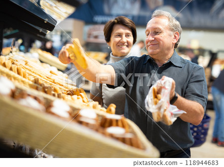 Couple chooses sweet puffs in bakery Couple chooses sweet puffs in bakery 118944683