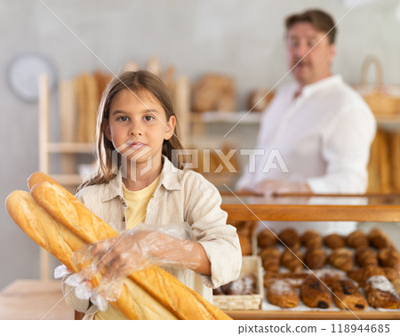Portrait of little female customer holding bread in his hands in private bakery Portrait of little female customer holding bread in his hands in private bakery 118944685