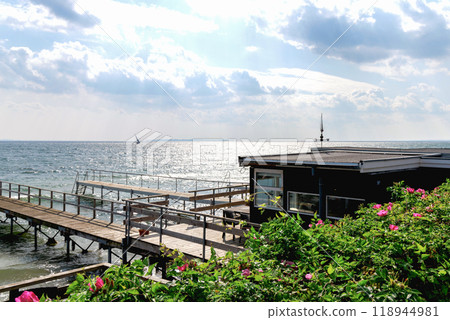 Beautiful seascape with sailing boat in the distance and pier Beautiful seascape with sailing boat in the distance and pier 118944981