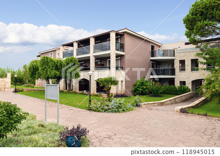 Modern buildings on the island of Crete, Greece. Hotel area and palm trees. Luxury tropical apartment resort complex. 118945015