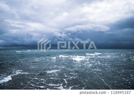Dramatic seascape in dark colors. Dark sky with clouds over the stormy sea. 118945187